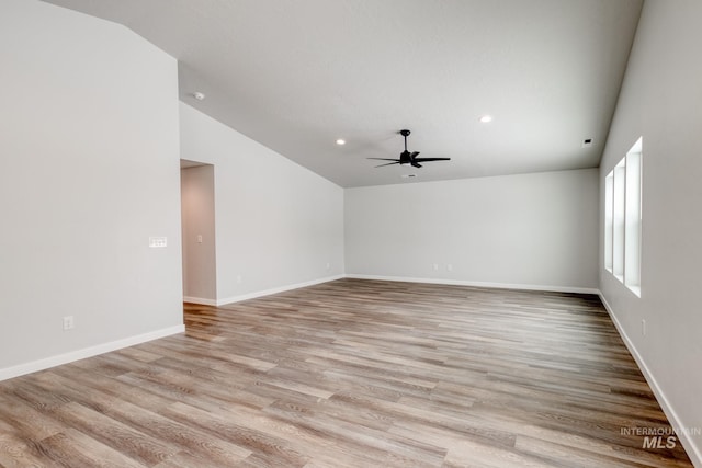 empty room with vaulted ceiling, light wood-type flooring, and a ceiling fan