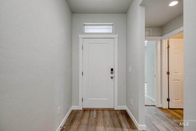 doorway featuring visible vents, wood finished floors, and baseboards