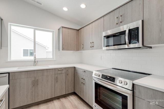 kitchen featuring a sink, visible vents, light brown cabinetry, light countertops, and appliances with stainless steel finishes