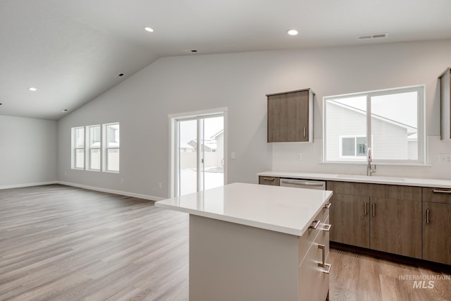 kitchen featuring a center island, a wealth of natural light, visible vents, and a sink