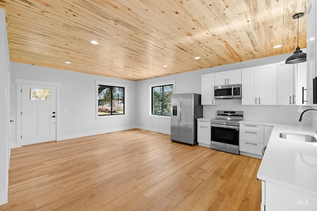 kitchen with white cabinets, light hardwood / wood-style flooring, appliances with stainless steel finishes, and sink