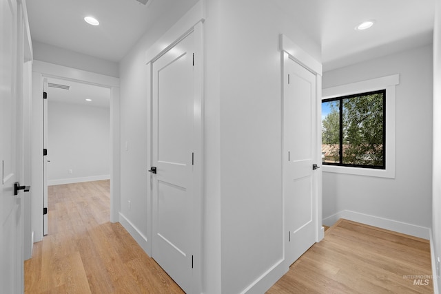 corridor with light hardwood / wood-style floors