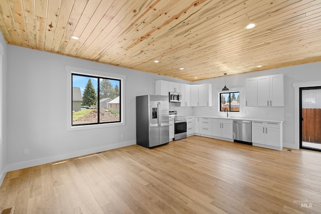 kitchen featuring appliances with stainless steel finishes, white cabinets, hanging light fixtures, light hardwood / wood-style floors, and wooden ceiling