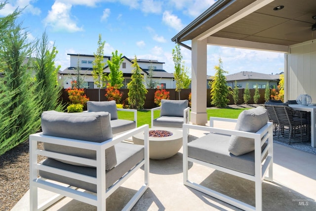 view of patio / terrace with fence, a residential view, and an outdoor living space with a fire pit
