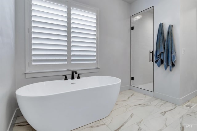 bathroom with baseboards, marble finish flooring, a stall shower, and plenty of natural light
