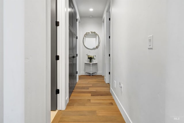 hall featuring baseboards, light wood-style floors, and recessed lighting