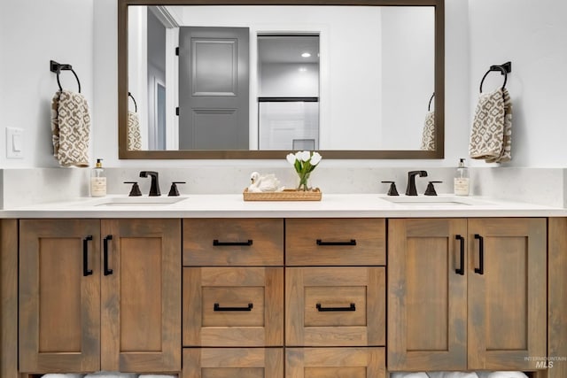bathroom with double vanity and a shower with door