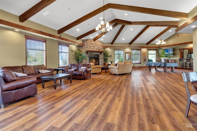 living area featuring a chandelier, beam ceiling, wood finished floors, healthy amount of natural light, and recessed lighting