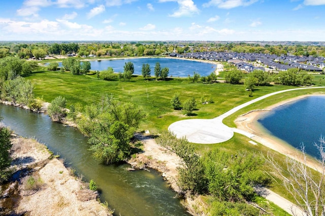 aerial view of residential area with a nearby body of water and a tree filled landscape