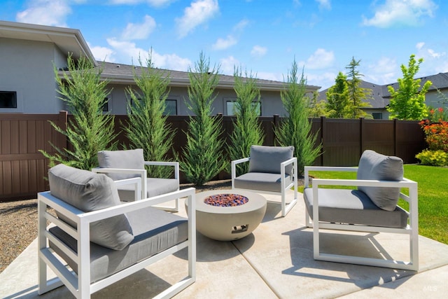 view of patio / terrace with a fenced backyard and an outdoor living space with a fire pit