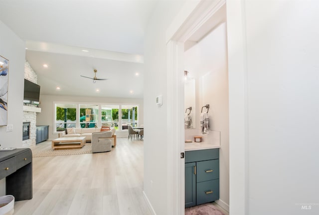 hallway with lofted ceiling and light hardwood / wood-style flooring