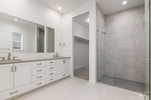 2372 N Leatherwood Ave, Star, ID 83669 - bathroom featuring a stall shower, recessed lighting, double vanity, a walk in closet, and baseboards