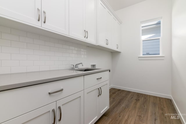 2372 N Leatherwood Ave, Star, ID 83669 - kitchen featuring a sink, decorative backsplash, dark wood-style floors, baseboards, and white cabinets