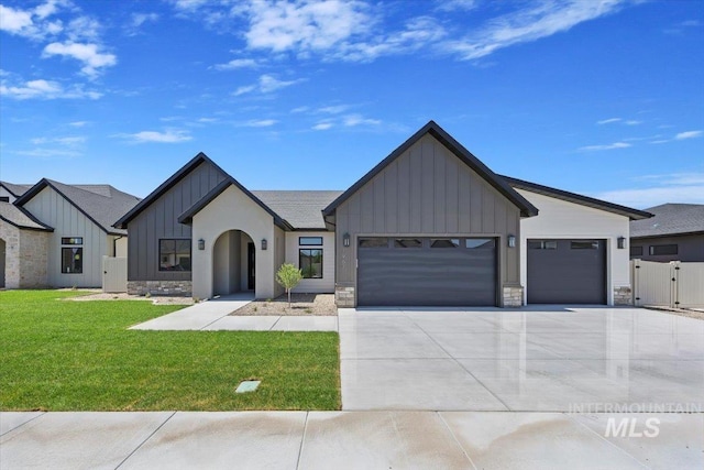1967 Red Rock Way, Twin Falls, ID 83301 - view of front of property with board and batten siding, a garage, concrete driveway, a front yard, and stone siding
