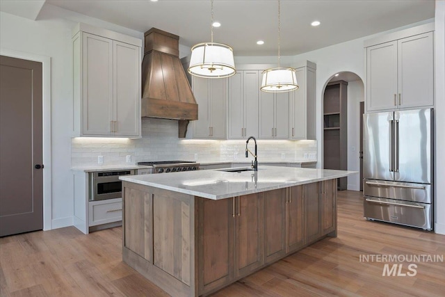 1967 Red Rock Way, Twin Falls, ID 83301 - kitchen featuring stainless steel appliances, custom range hood, arched walkways, tasteful backsplash, and recessed lighting
