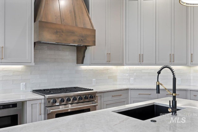 1967 Red Rock Way, Twin Falls, ID 83301 - kitchen featuring stainless steel appliances, custom exhaust hood, decorative backsplash, and light stone counters