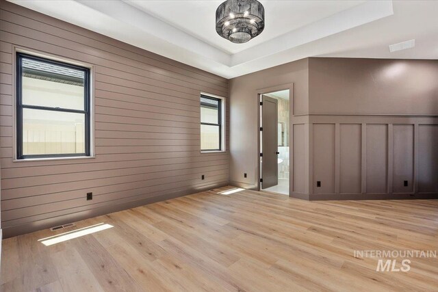 1967 Red Rock Way, Twin Falls, ID 83301 - unfurnished room featuring light wood finished floors, a chandelier, a decorative wall, and a tray ceiling