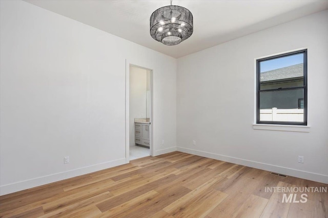 1967 Red Rock Way, Twin Falls, ID 83301 - empty room with light wood-type flooring and a chandelier