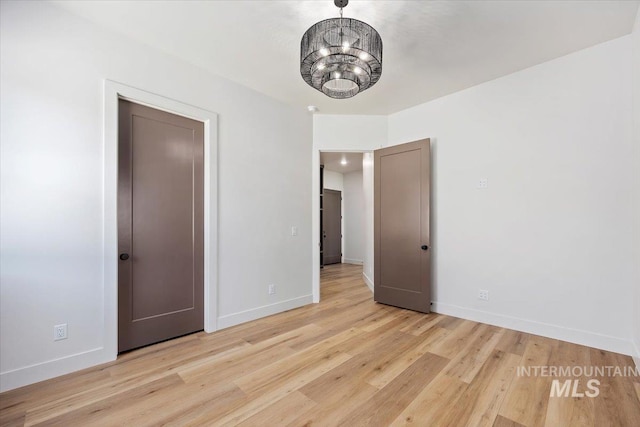 1967 Red Rock Way, Twin Falls, ID 83301 - unfurnished bedroom with light wood-type flooring and a chandelier