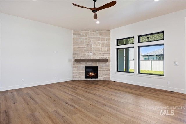 1967 Red Rock Way, Twin Falls, ID 83301 - unfurnished living room with a ceiling fan, wood finished floors, a stone fireplace, and recessed lighting
