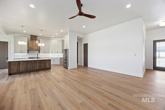 1967 Red Rock Way, Twin Falls, ID 83301 - kitchen featuring custom range hood, light countertops, decorative backsplash, open floor plan, and recessed lighting