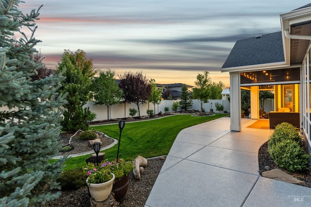 yard at dusk with a patio area