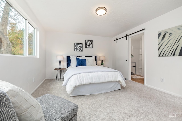 bedroom with a barn door and light carpet