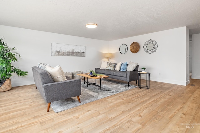 living room featuring light hardwood / wood-style flooring and a textured ceiling