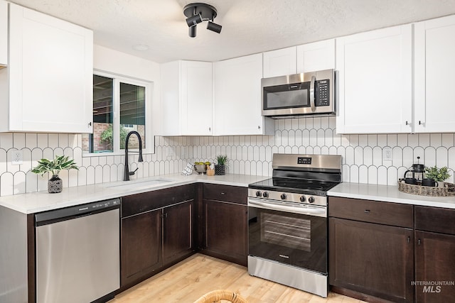 kitchen featuring white cabinetry, sink, and appliances with stainless steel finishes