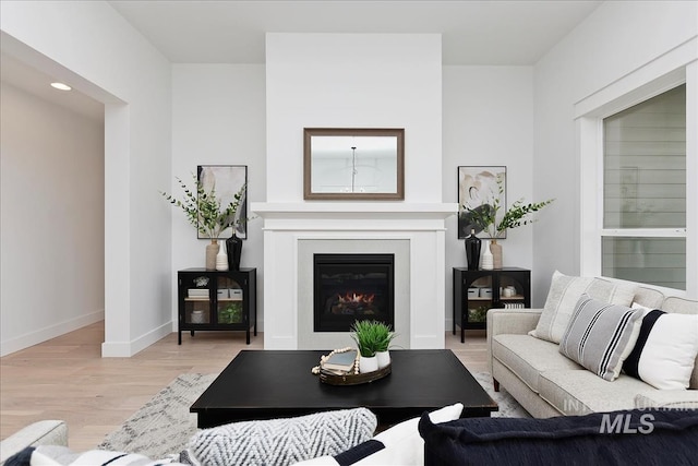 7625 W Whisper Ridge Dr, Meridian, ID 83646 - living room with light wood-style flooring and a glass covered fireplace