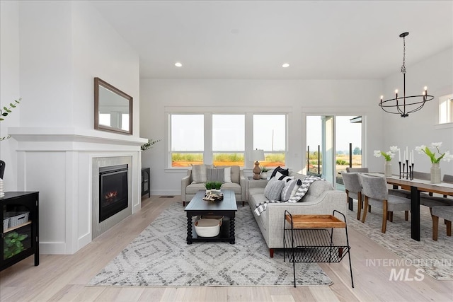 7625 W Whisper Ridge Dr, Meridian, ID 83646 - living room featuring a chandelier, a glass covered fireplace, light wood-style flooring, and recessed lighting