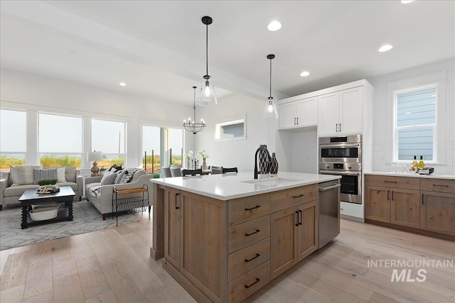 7625 W Whisper Ridge Dr, Meridian, ID 83646 - kitchen with appliances with stainless steel finishes, light wood finished floors, recessed lighting, open floor plan, and light countertops