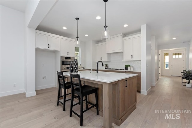 7625 W Whisper Ridge Dr, Meridian, ID 83646 - kitchen featuring tasteful backsplash, light countertops, light wood-style flooring, white cabinets, and recessed lighting