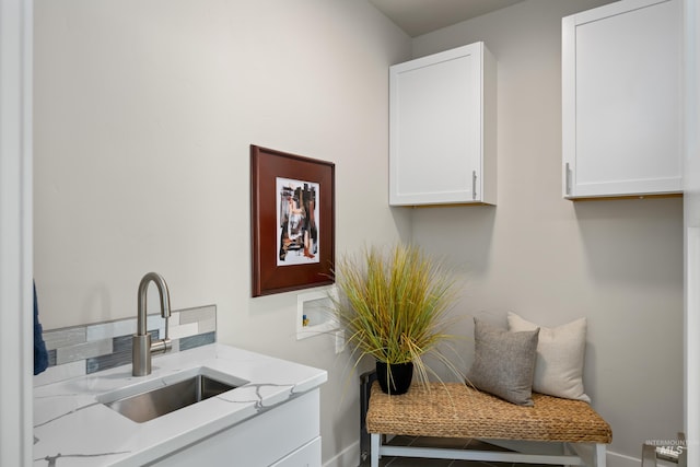 washroom with cabinets, washer hookup, and sink