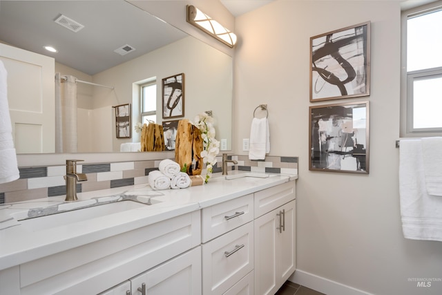 bathroom with vanity, a shower with shower curtain, a healthy amount of sunlight, and decorative backsplash