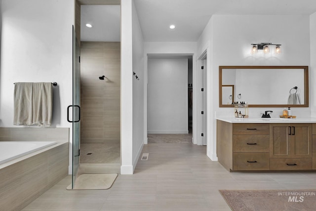 bathroom with tile patterned flooring, vanity, and independent shower and bath