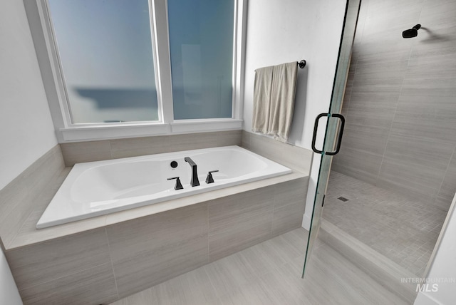 bathroom with tile patterned floors and independent shower and bath