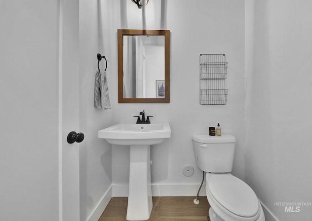 bathroom with hardwood / wood-style flooring, sink, and toilet