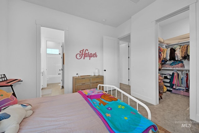 carpeted bedroom featuring a walk in closet, connected bathroom, and a closet