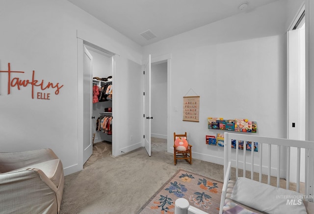 bedroom with a walk in closet, carpet flooring, and a closet