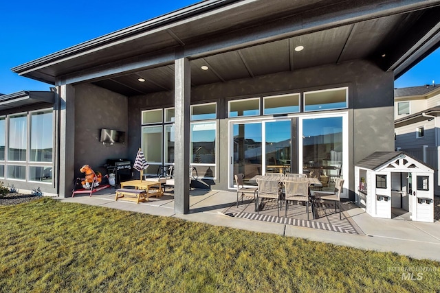 rear view of property with a patio and a lawn