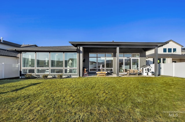 rear view of property featuring a yard and a patio area