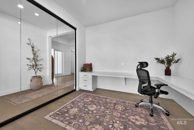 office area featuring built in desk and dark hardwood / wood-style flooring