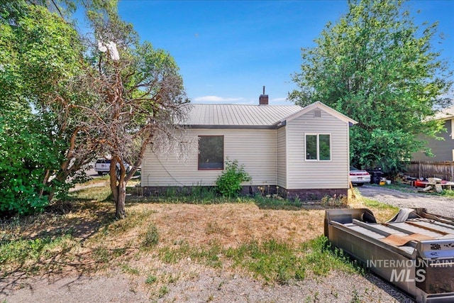 202E 2nd St, Shoshone, ID 83352 - view of home's exterior with a metal roof and a chimney