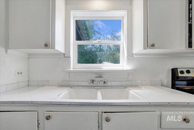 202E 2nd St, Shoshone, ID 83352 - kitchen with white cabinets, light countertops, and tasteful backsplash