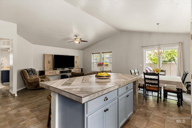 1814 N Rosedust Dr, Kuna, ID 83634 - kitchen featuring vaulted ceiling, a ceiling fan, healthy amount of natural light, open floor plan, and a center island