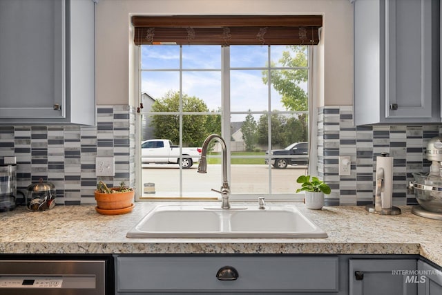 1814 N Rosedust Dr, Kuna, ID 83634 - kitchen with gray cabinets, a sink, dishwasher, decorative backsplash, and light countertops