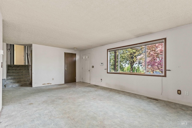 3709 11th St, Lewiston, ID 83501 - spare room featuring stairway, carpet flooring, a textured ceiling, and visible vents