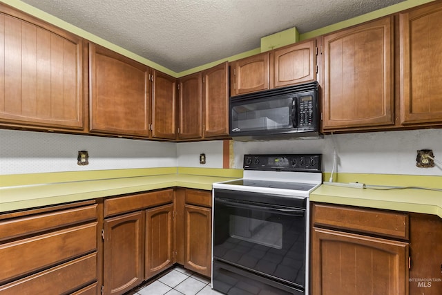 3709 11th St, Lewiston, ID 83501 - kitchen featuring a textured ceiling, black microwave, electric range oven, light countertops, and light tile patterned floors