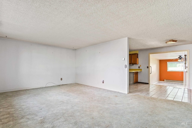 3709 11th St, Lewiston, ID 83501 - empty room with a baseboard heating unit, a textured ceiling, light colored carpet, and light tile patterned floors